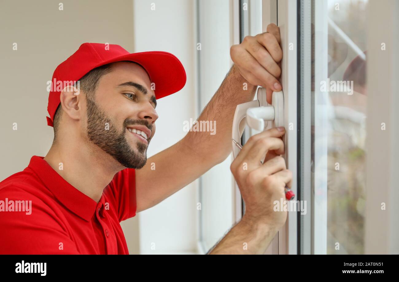 Young worker installing window in flat Stock Photo