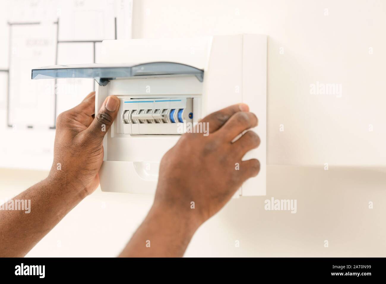 African-American electrician performing wiring in room Stock Photo