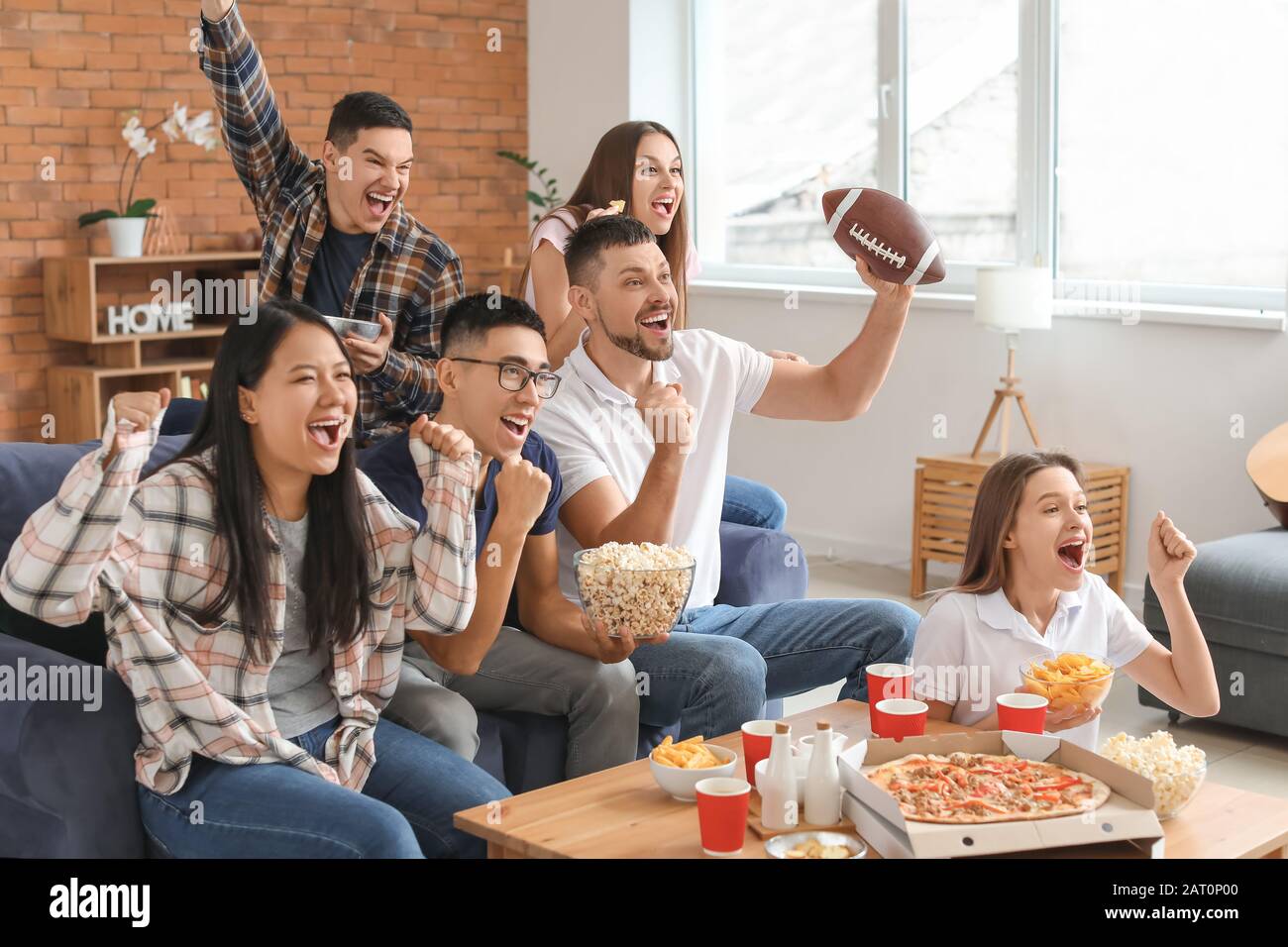 Group of fans watching rugby on TV Stock Photo