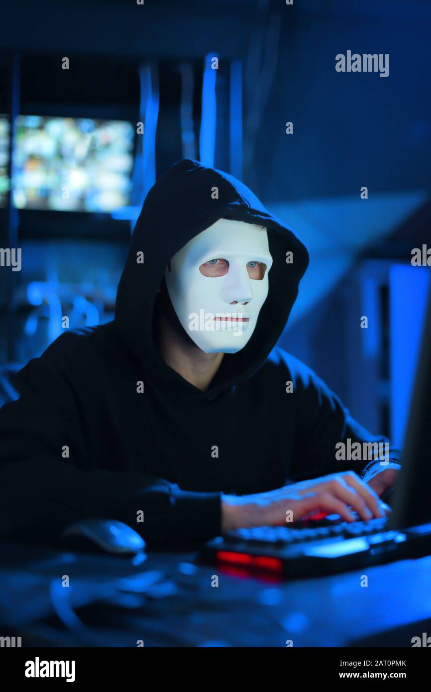 Professional hacker using computer in dark room Stock Photo