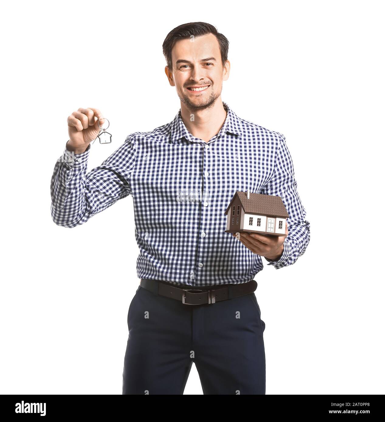 Male real estate agent with key and model of house on white background ...