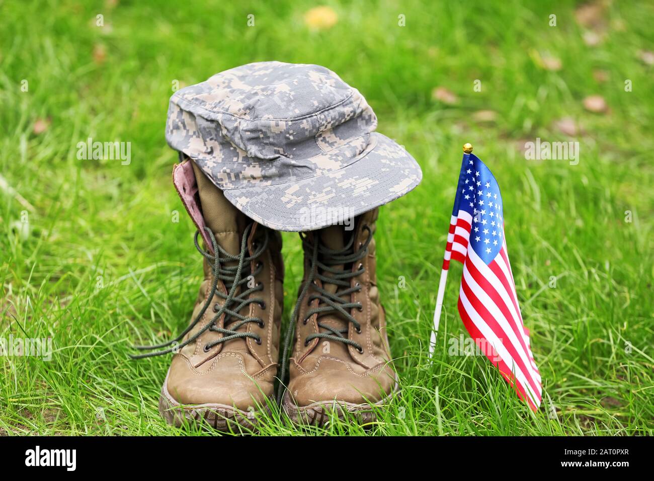 Military boots, hat and USA flag outdoors. Memorial Day celebration ...