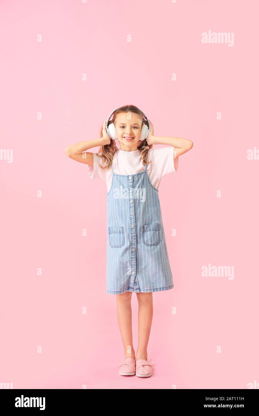 Cute little girl with headphones on color background Stock Photo - Alamy