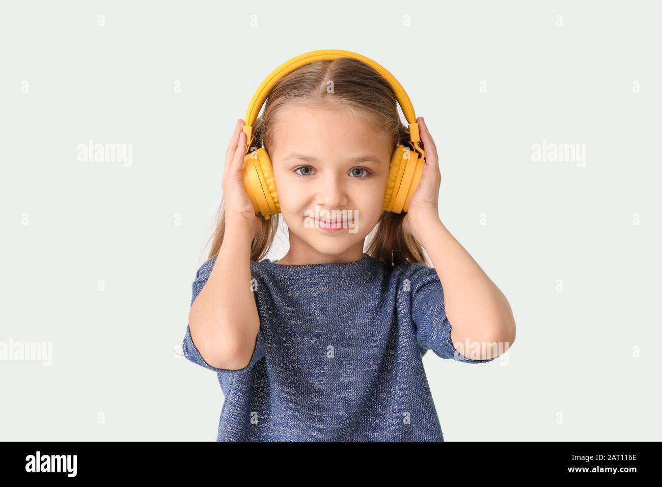 Cute little girl with headphones on white background Stock Photo - Alamy