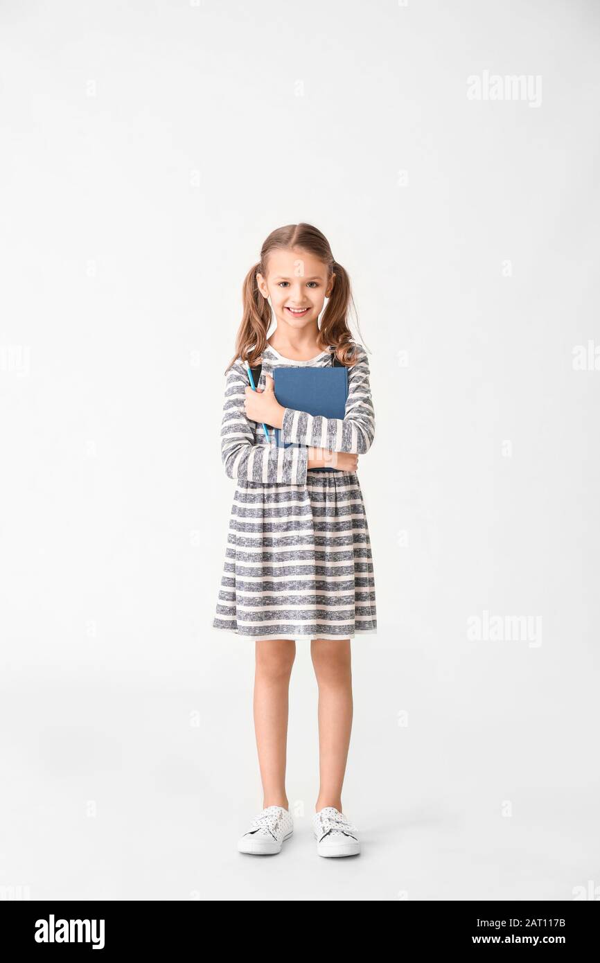 Cute little girl with book on white background Stock Photo - Alamy