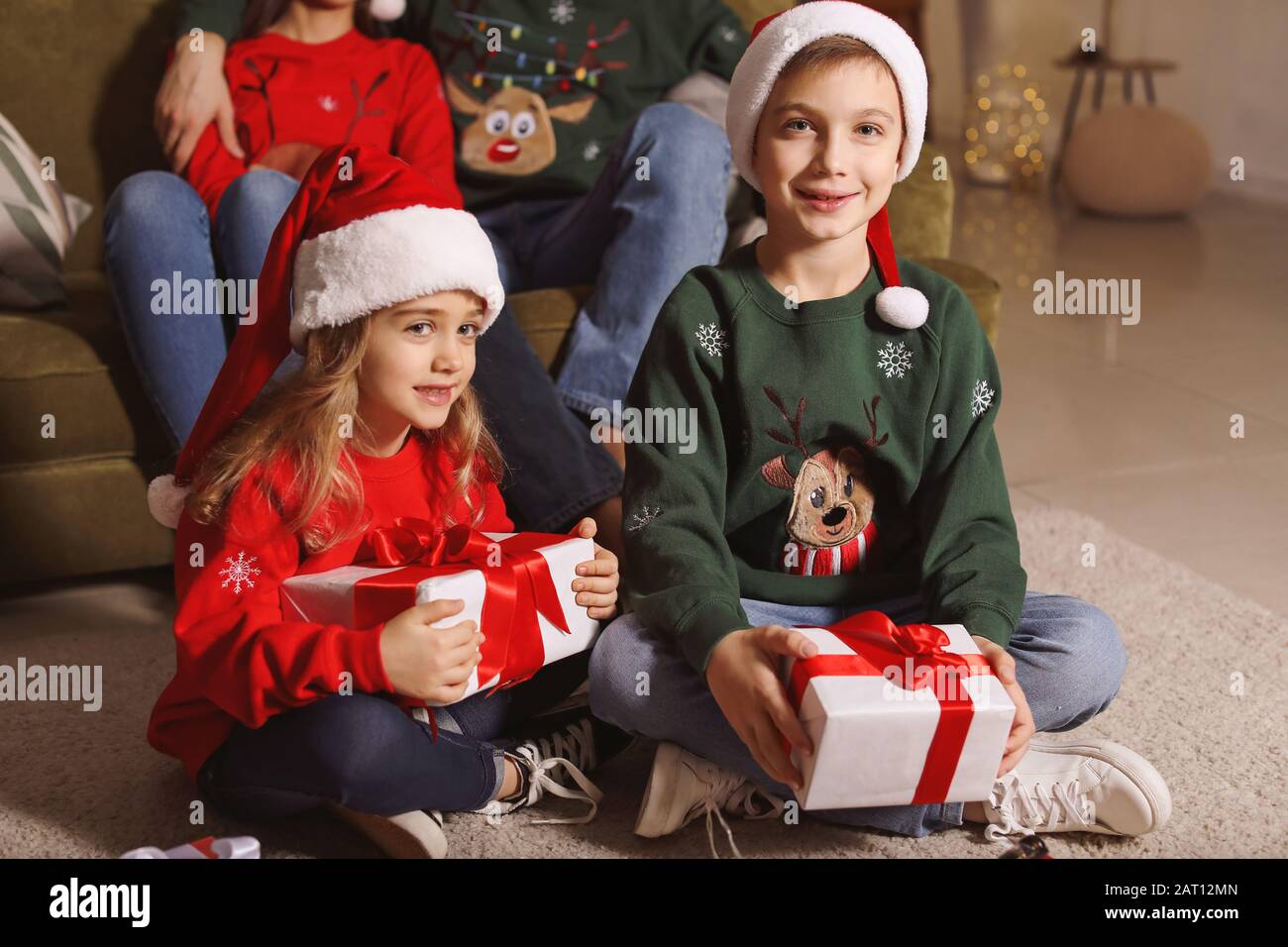 little-children-with-christmas-gifts-and-their-parents-at-home-stock