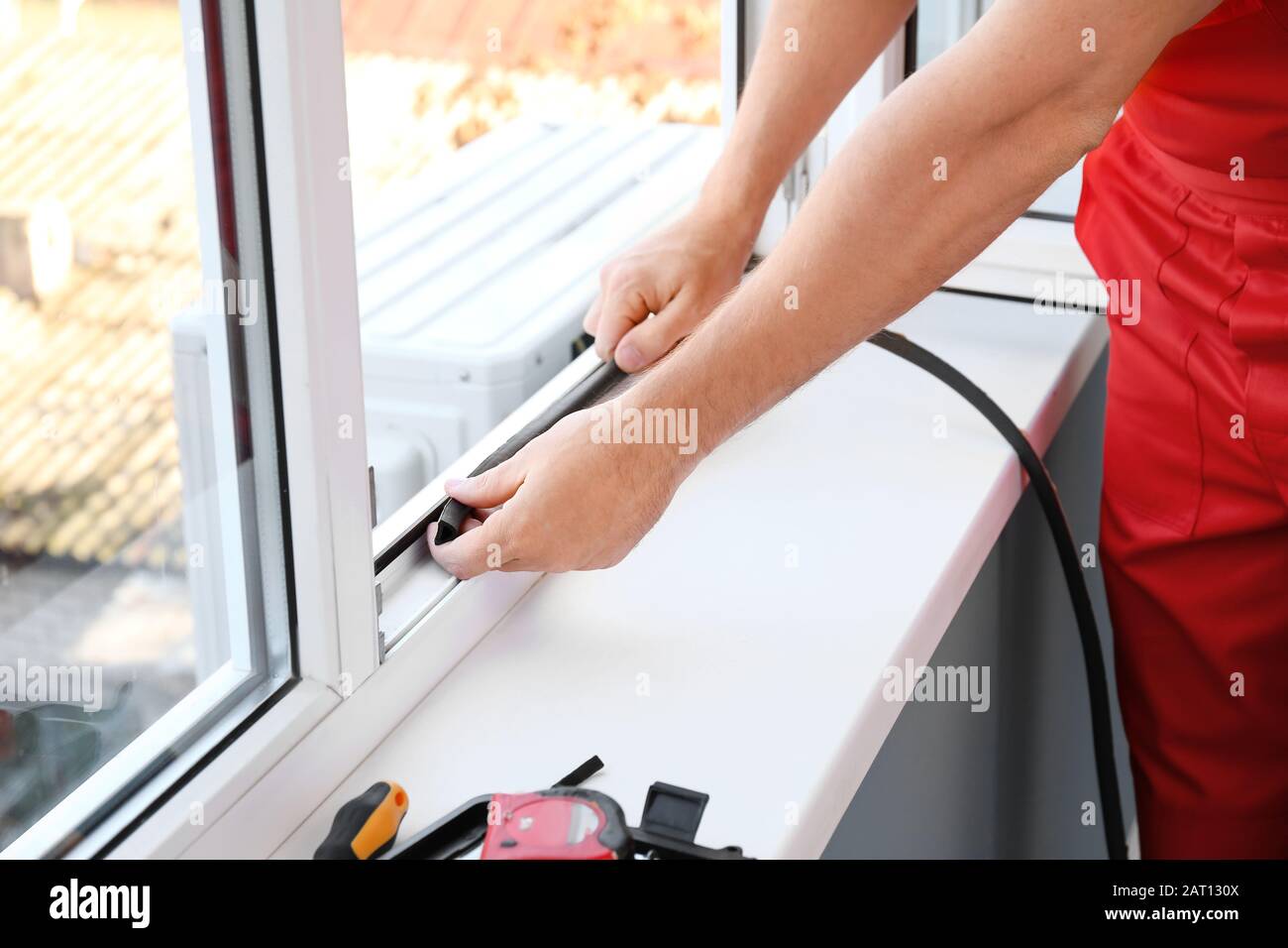 Window Apprentice Male worker installing window in flat Stock Photo - Alamy
