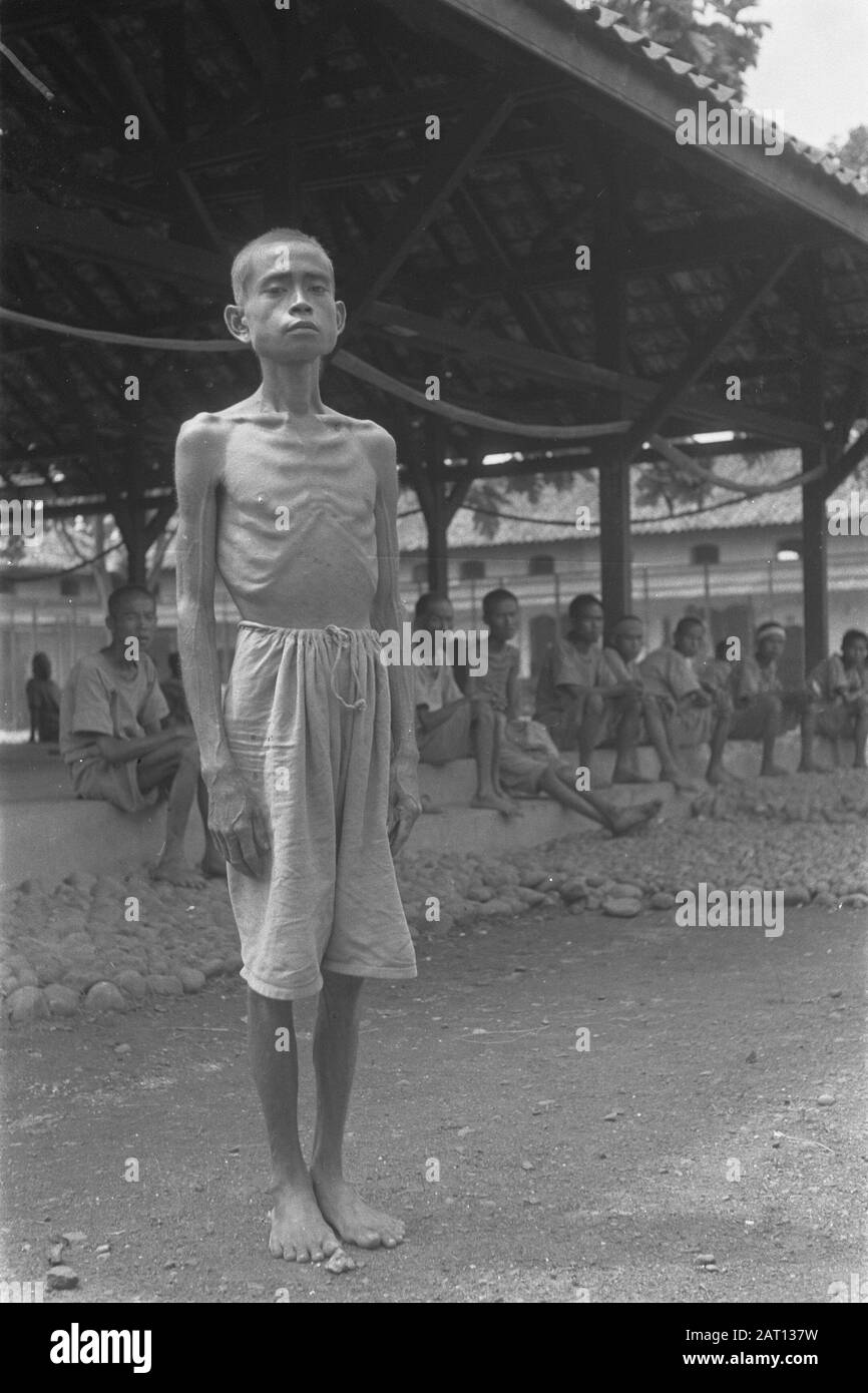 Action Outdoor Care 1st series  An emaciated Indonesian man poses in front of the camera acheter him a row of men, for them piles of boulders Annotation: Action n.a.v. subversive actions of TRI and the republican resident. The residence office and telephone office were occupied by Dutch troops Date: 17 December 1948 Location: Bogor, Indonesia, Dutch East Indies Stock Photo