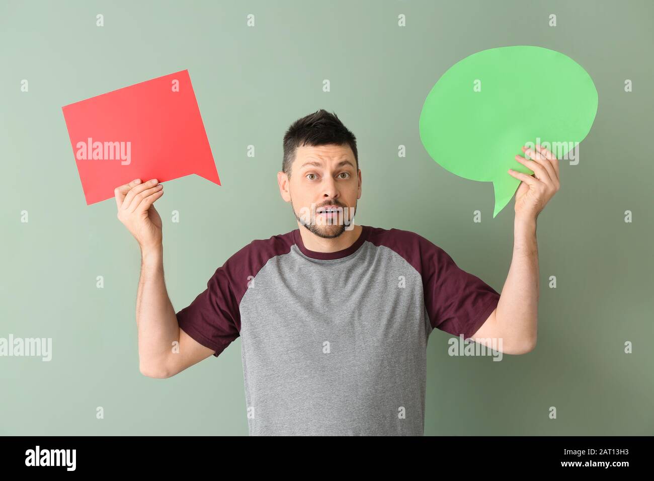 Man with blank speech bubbles on color background Stock Photo