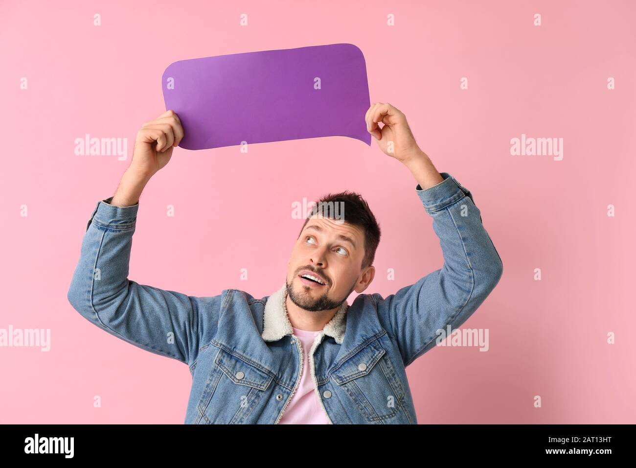 Man with blank speech bubble on color background Stock Photo