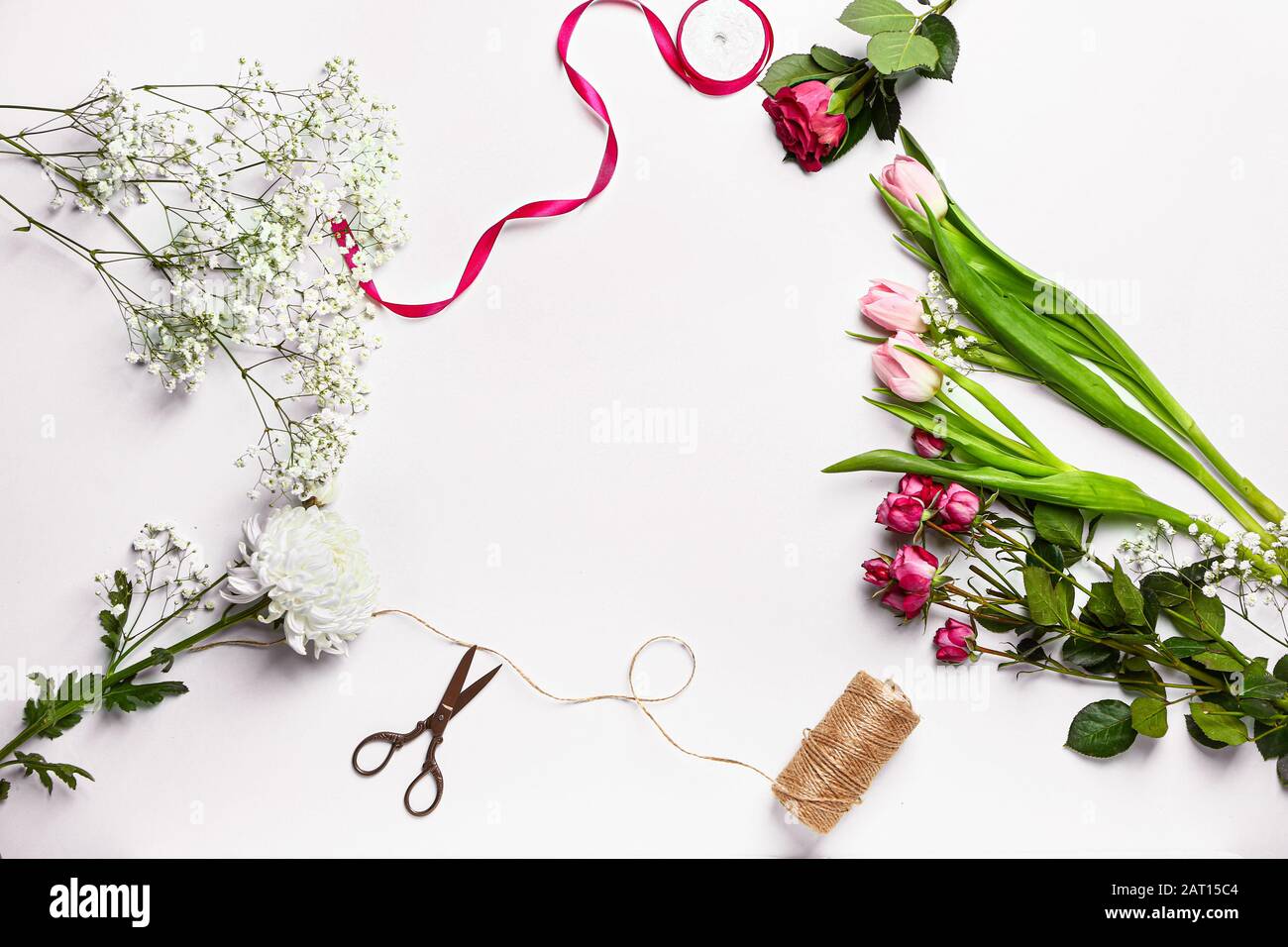 Frame made of supplies of florist with fresh flowers on white ...