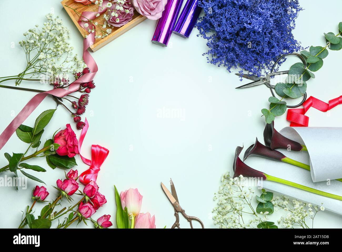 Frame made of supplies of florist with fresh flowers on white ...