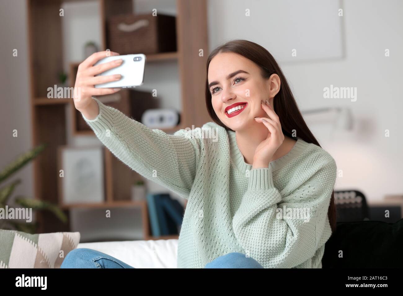 Beautiful young woman taking selfie at home Stock Photo - Alamy