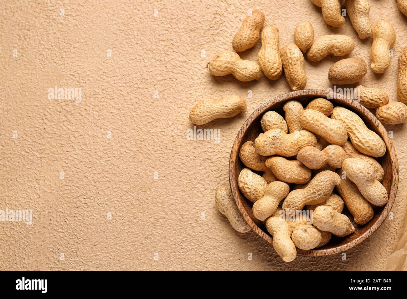 Plate with peanuts on color background Stock Photo