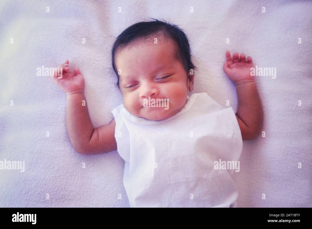 Smiling Indian baby girl while sleeping Stock Photo - Alamy