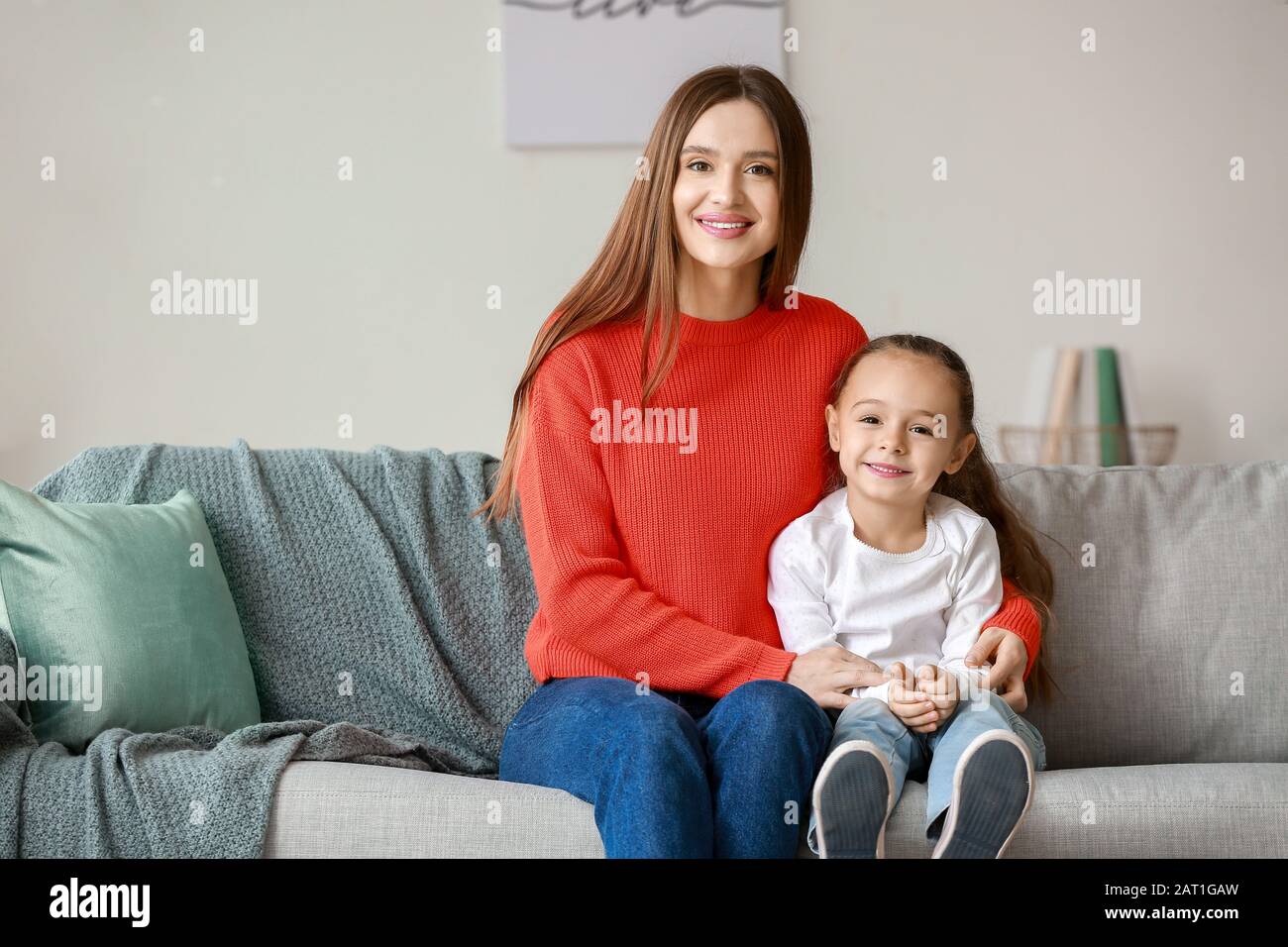 Young woman with her little daughter spending time together at home Stock Photo