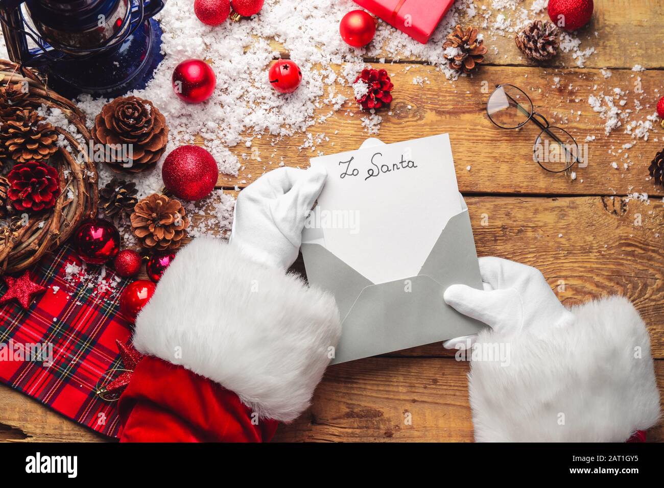 Santa Claus opening letter on table Stock Photo