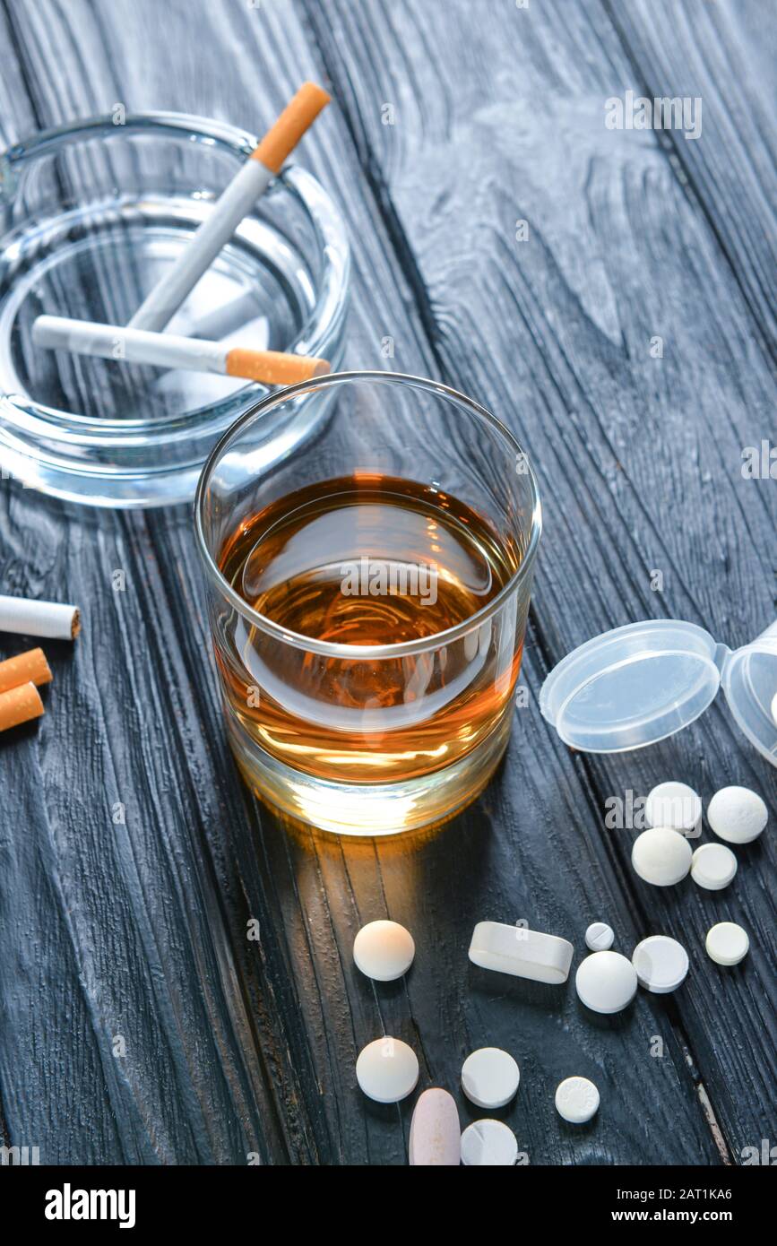 are tobacco and alcohol drugs Glass of alcohol, cigarettes and drugs on table. Concept of bad habits  Stock Photo