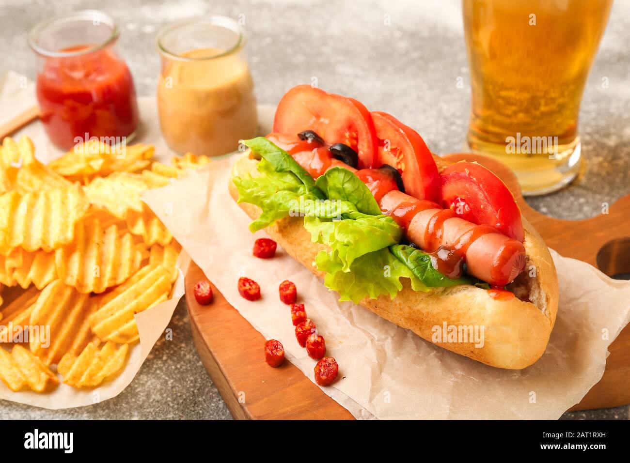 Tasty hot dog, chips and beer on table Stock Photo