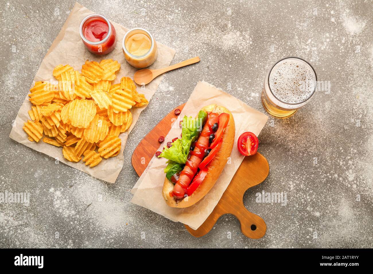 Tasty hot dog, chips and beer on table Stock Photo