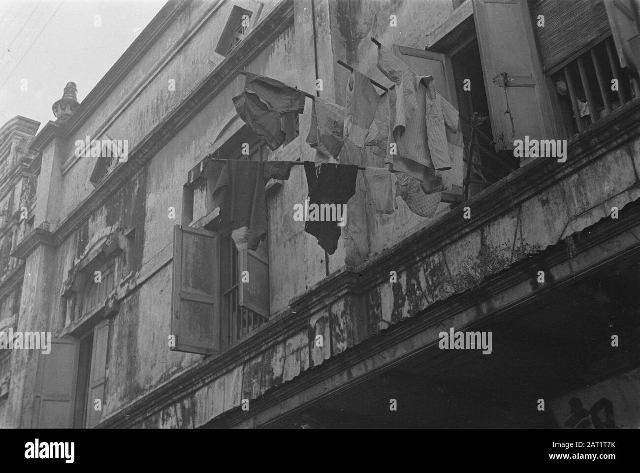 Photo Reportage Palembangs  Laundry hangs to dry on sticks stuck from a window of a building in PalembangDate: 1947 Location: Indonesia, Dutch East Indies  :  Unknown/DLC Stock Photo