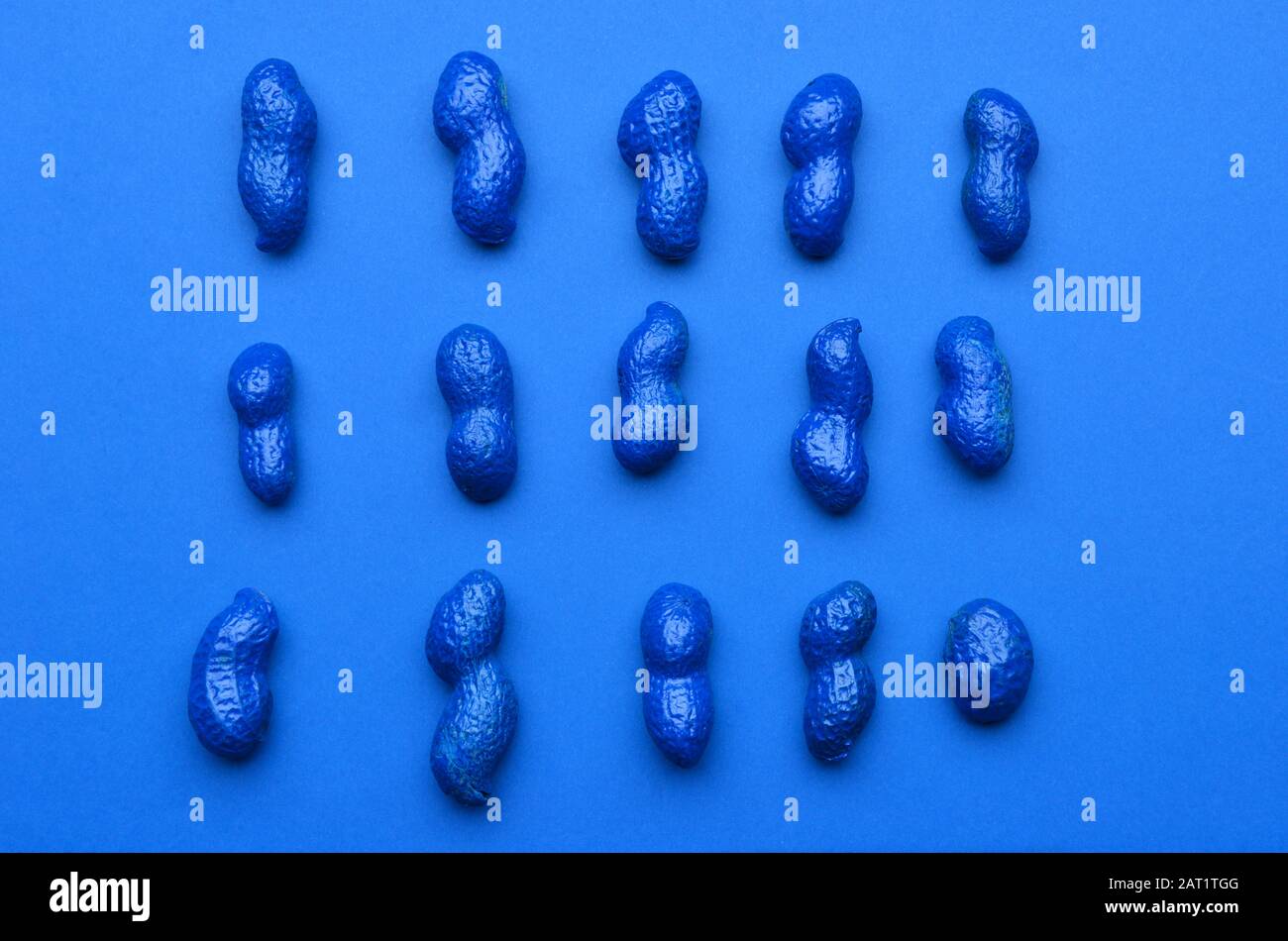 Blue painted peanuts on color background Stock Photo