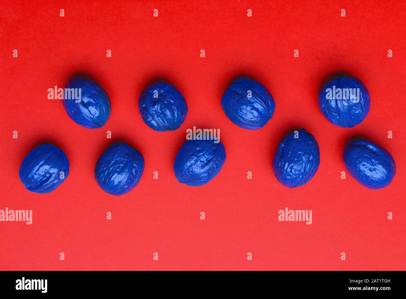 Blue painted walnuts on color background Stock Photo