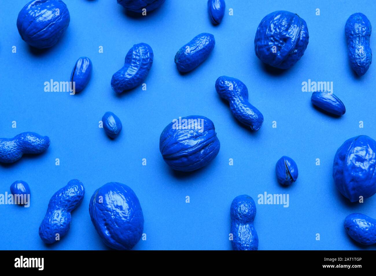 Blue painted nuts on color background Stock Photo