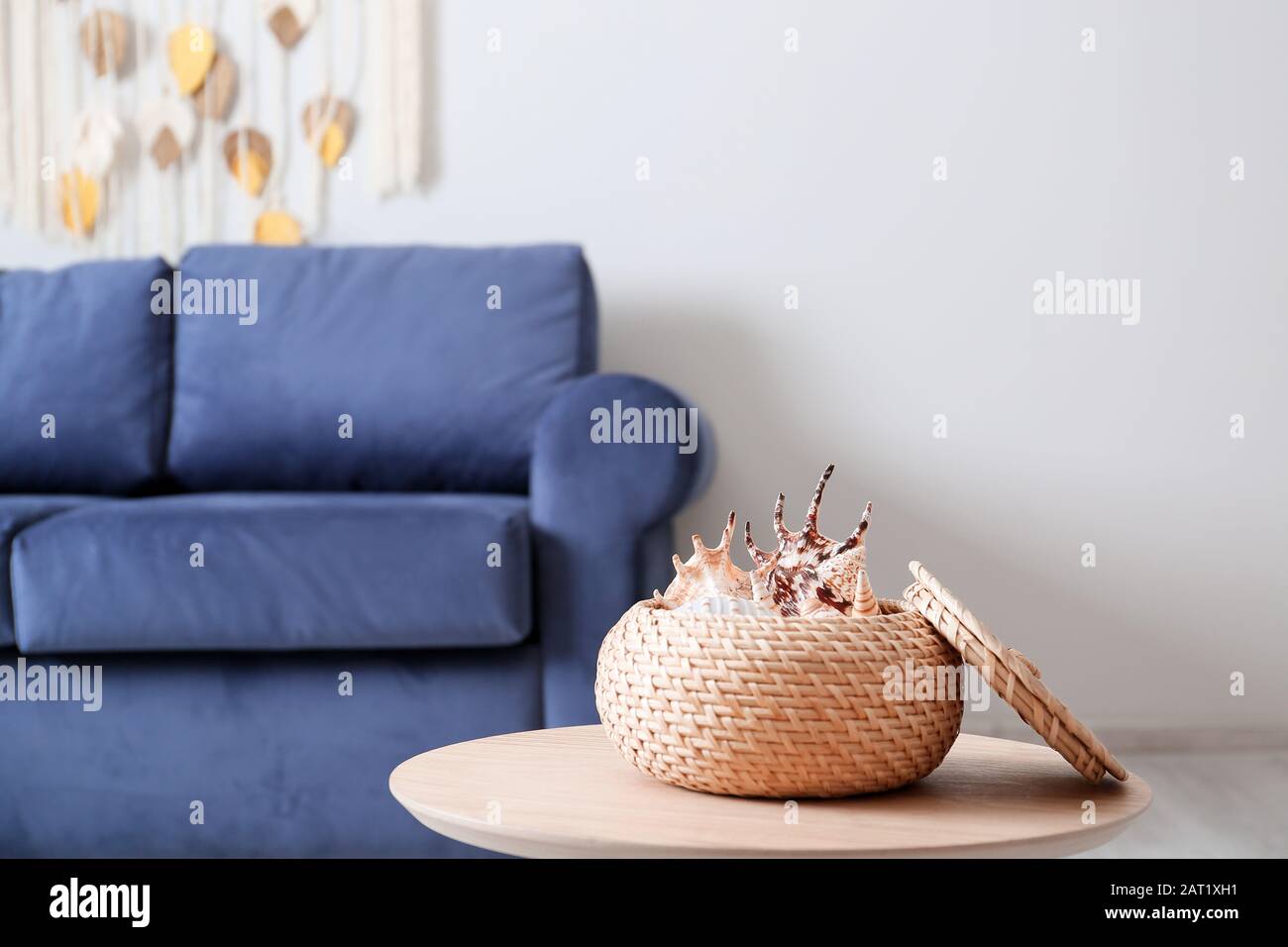 Box with sea shells on table in room Stock Photo