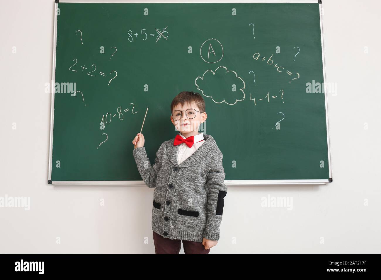 Little schoolboy near blackboard in classroom Stock Photo - Alamy