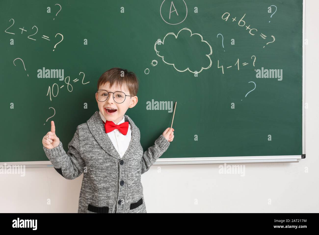 Little schoolboy near blackboard in classroom Stock Photo - Alamy