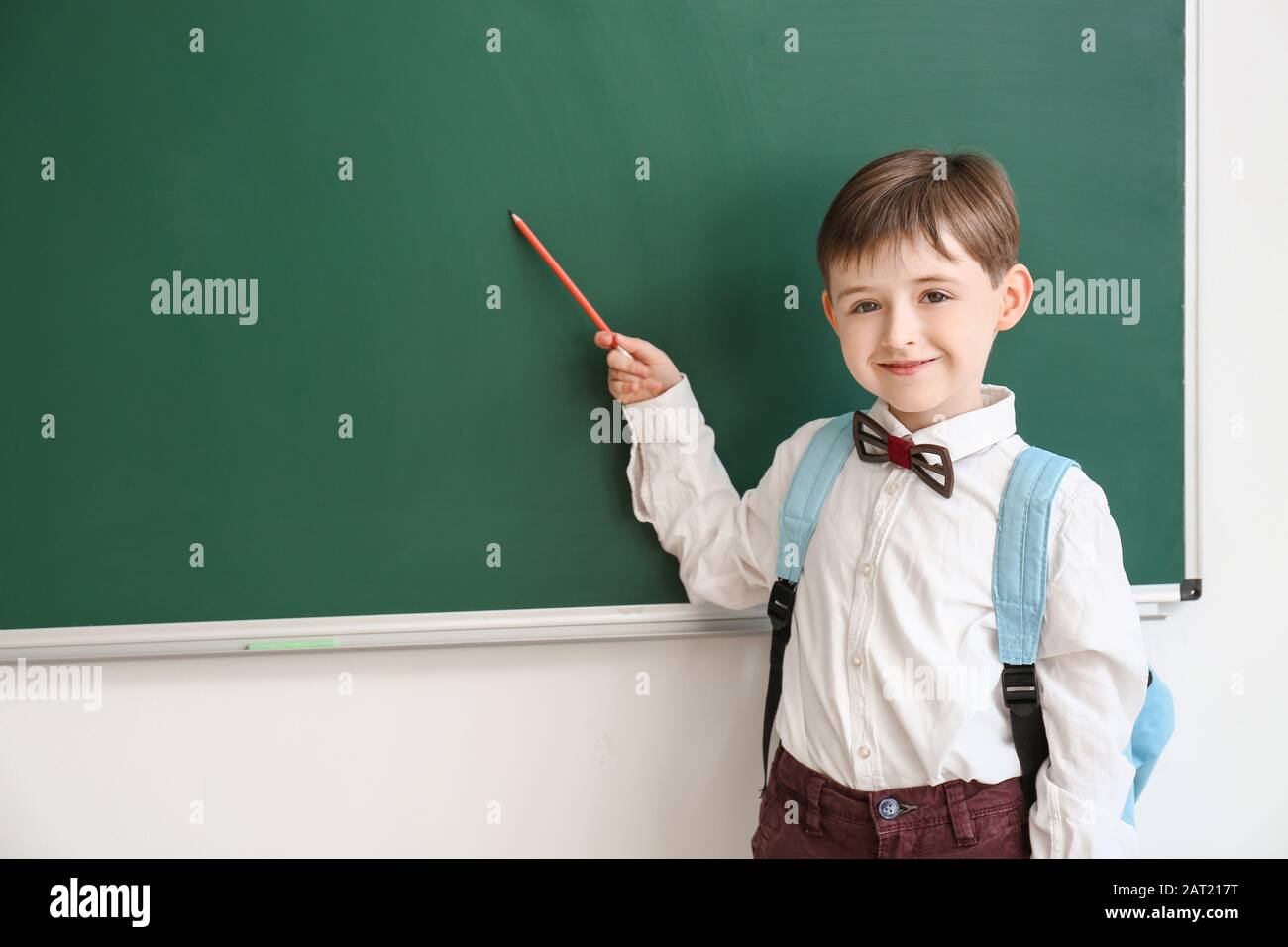 Little schoolboy near blackboard in classroom Stock Photo - Alamy