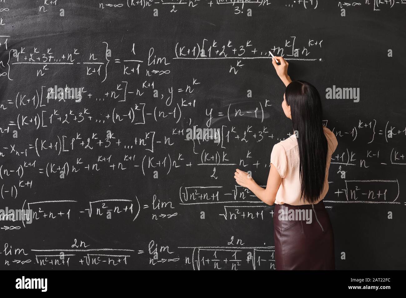 Teacher Writing On Blackboard