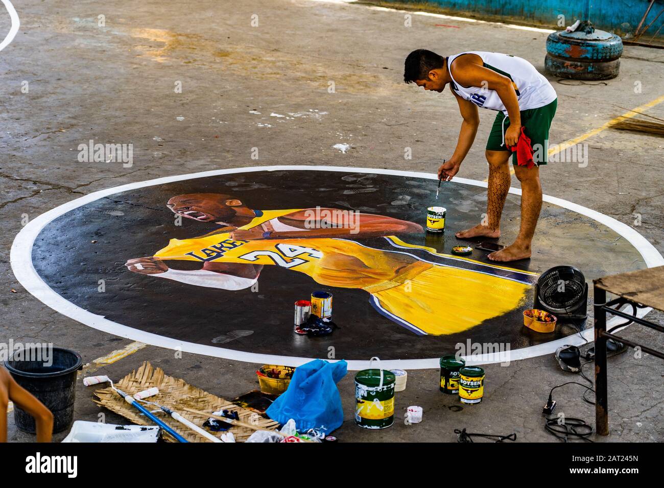 Cebu City, Philippines. 30th Jan, 2020. Filipino artist Laurence Yuyen Ravina painting a mural of his basketball hero Kobe Bryant on the local community court.Basketball loving kids in the area chipped in the money to buy the paints. With Basketball being the most popular sport in the Philippines many Filipinos have been coming to terms with the sad passing of the Basketball legend. Credit: imagegallery2/Alamy Live News Stock Photo