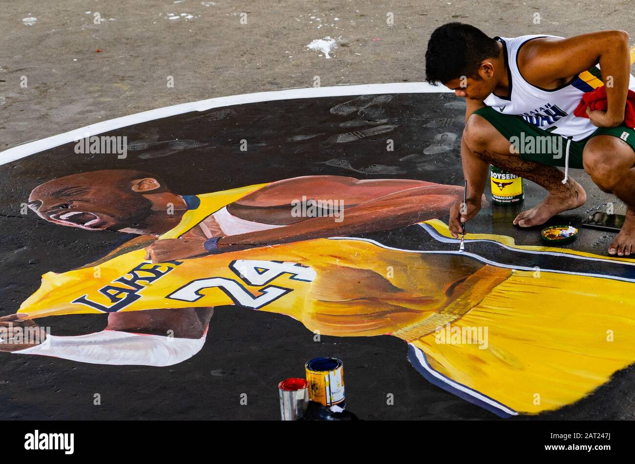 Cebu City, Philippines. 30th Jan, 2020. Filipino artist Laurence Yuyen Ravina painting a mural of his basketball hero Kobe Bryant on the local community court.Basketball loving kids in the area chipped in the money to buy the paints. With Basketball being the most popular sport in the Philippines many Filipinos have been coming to terms with the sad passing of the Basketball legend. Credit: imagegallery2/Alamy Live News Stock Photo