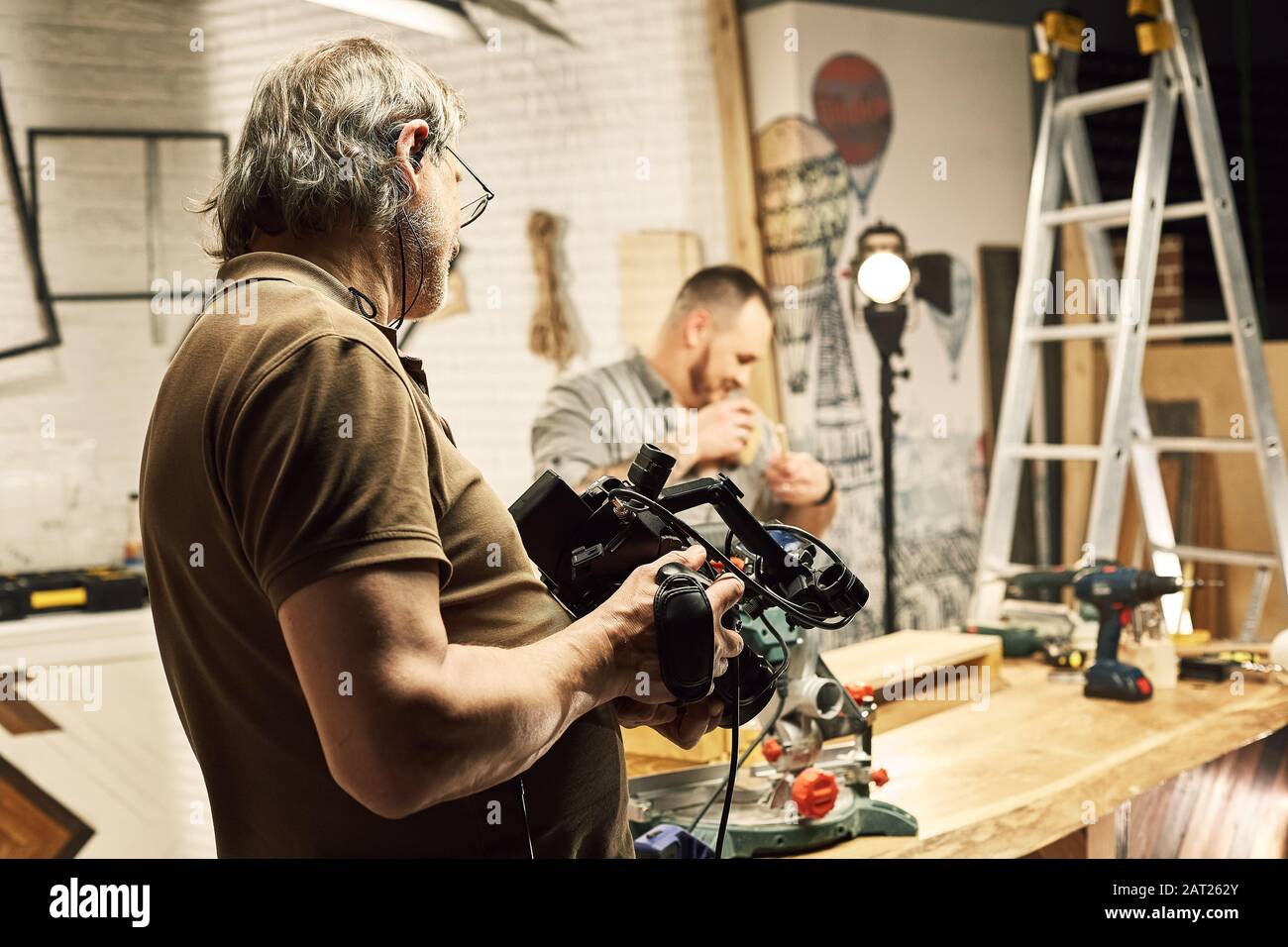 Video production backstage. Behind the scenes of creating video content, a  professional team of cameramen with a director filming commercial ads. Vide  Stock Photo - Alamy