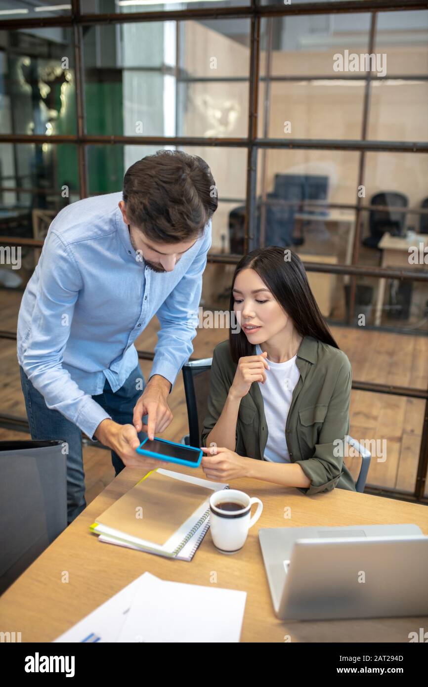 Two employees working in the office and looking involved Stock Photo ...