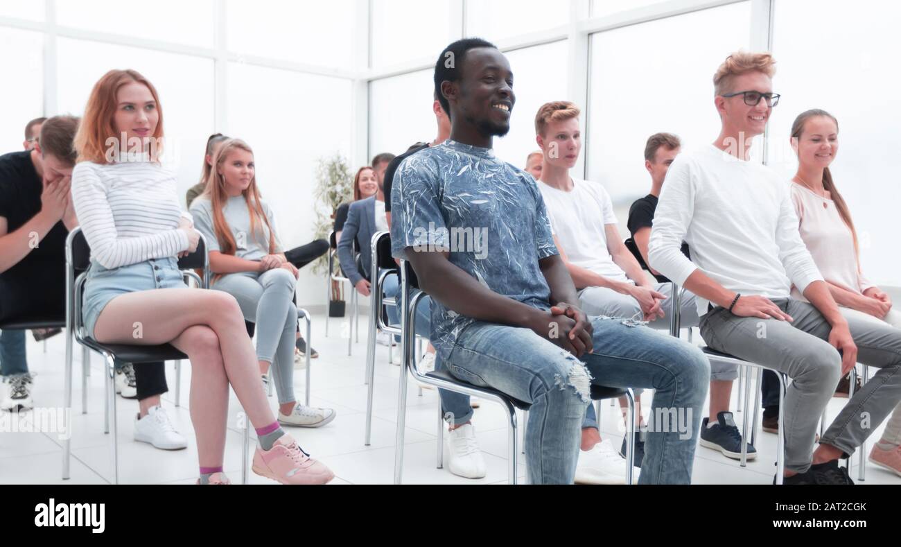 group of diverse young people sitting in a conference room Stock Photo ...