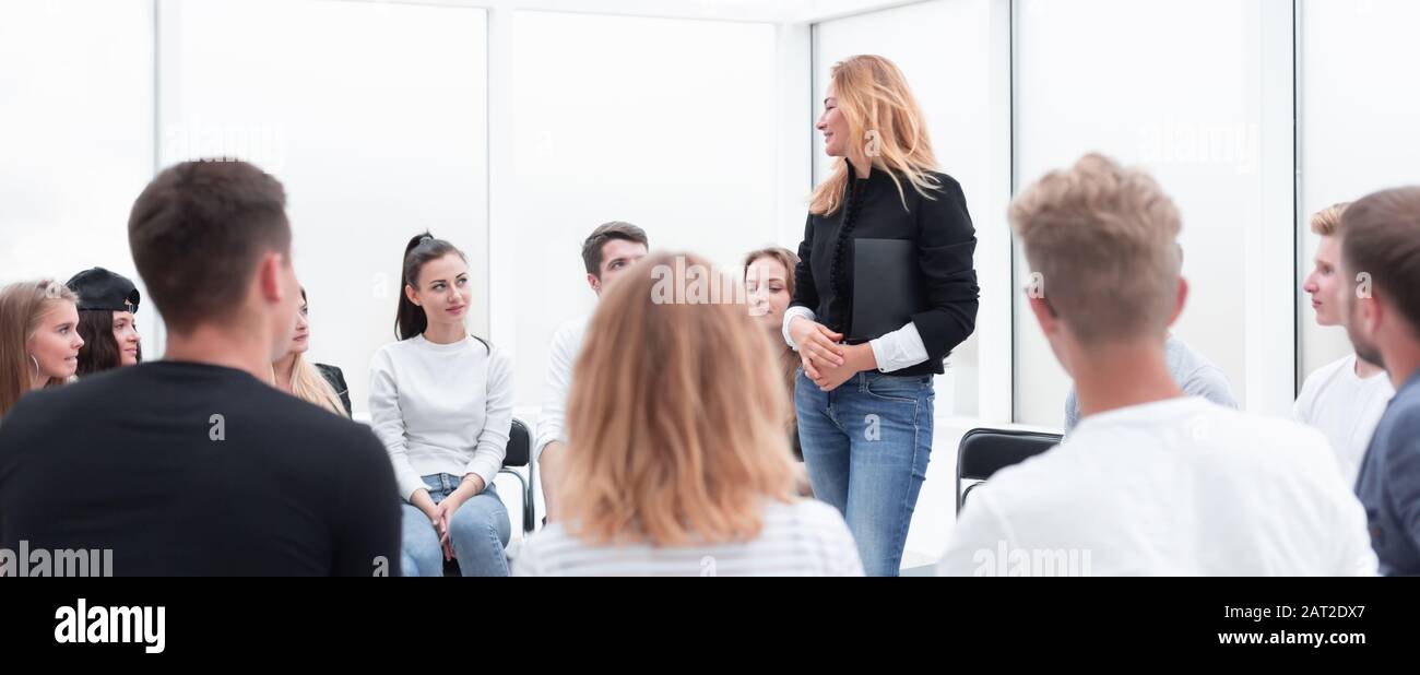 young woman standing in a circle of her colleagues. Stock Photo