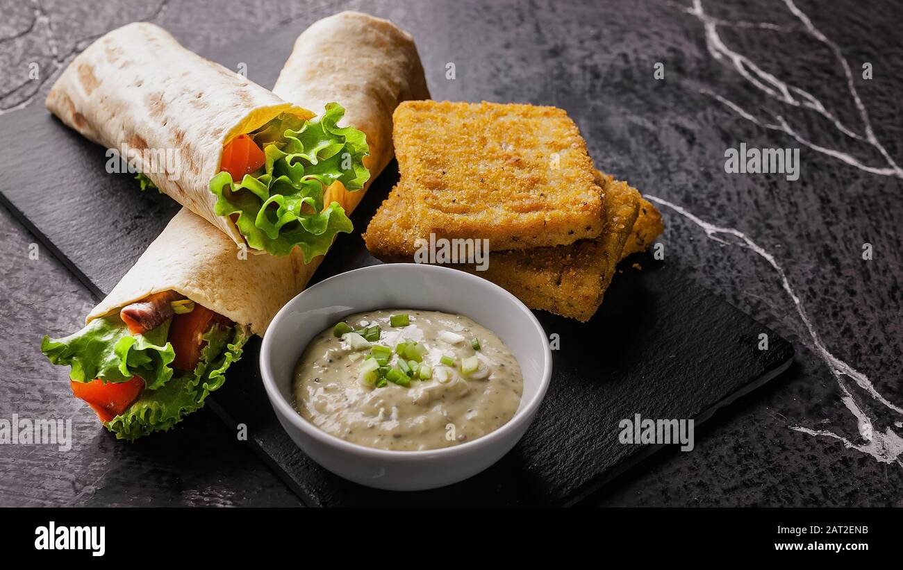 Food banner. Tortilla wrap with salmon and fresh salad, breaded fish ...