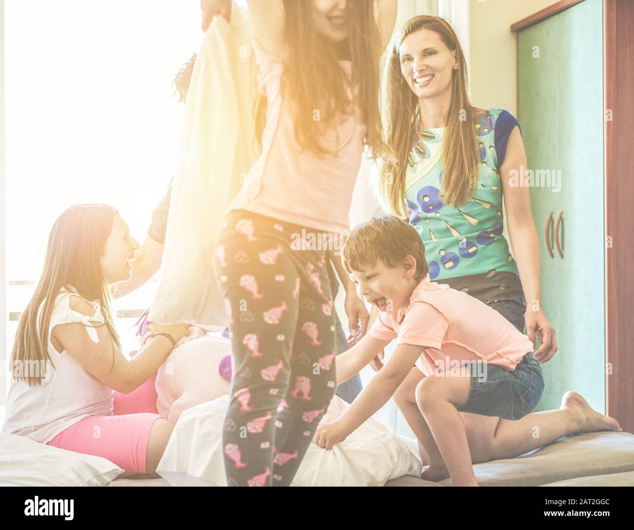 Happy Family Having Fun Inside Hotel Bed Room On Summer Vacation
