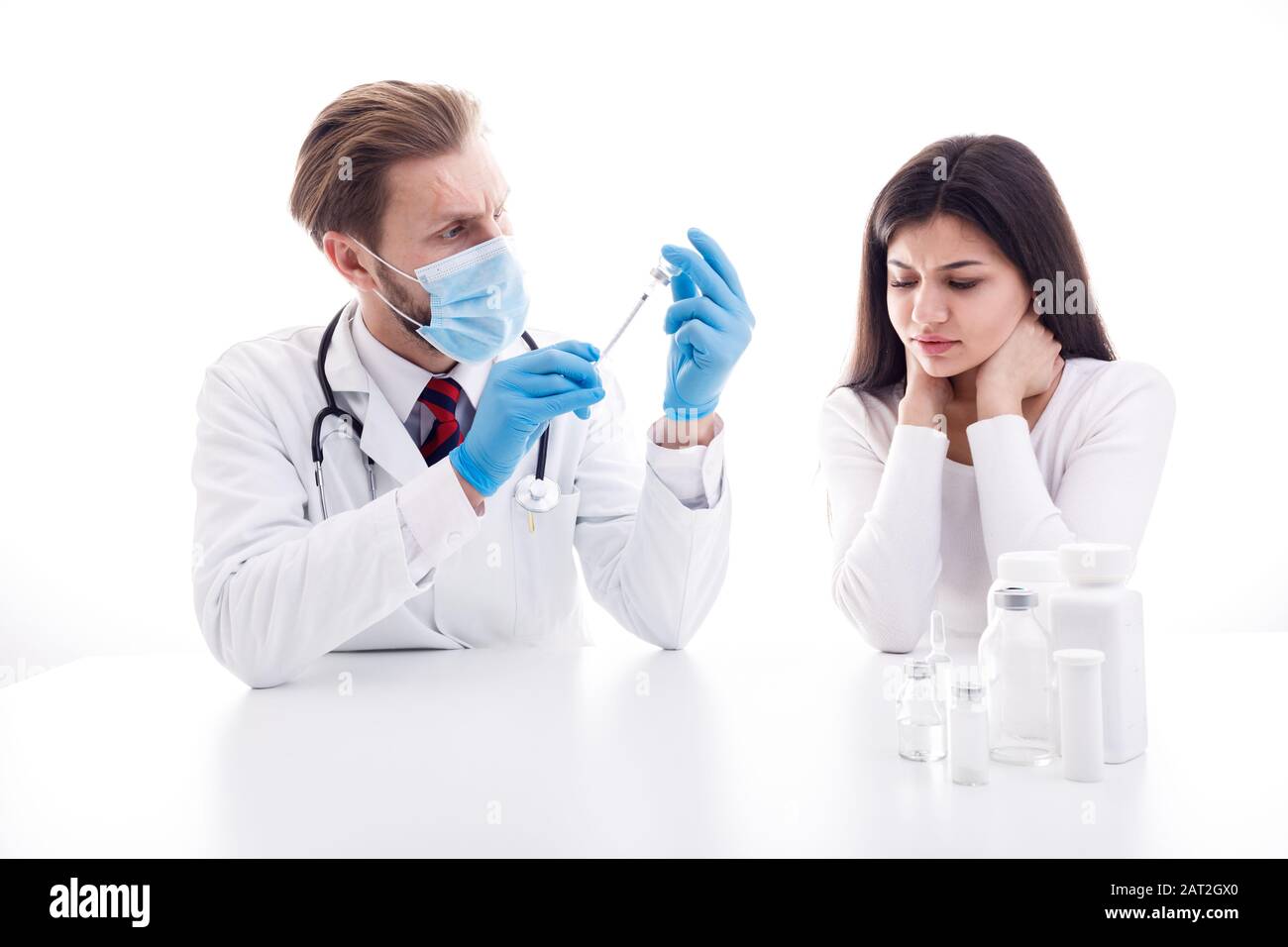 Careful Doctor in Mask Loading a Syringe of Vaccine While Patient Waiting Stock Photo