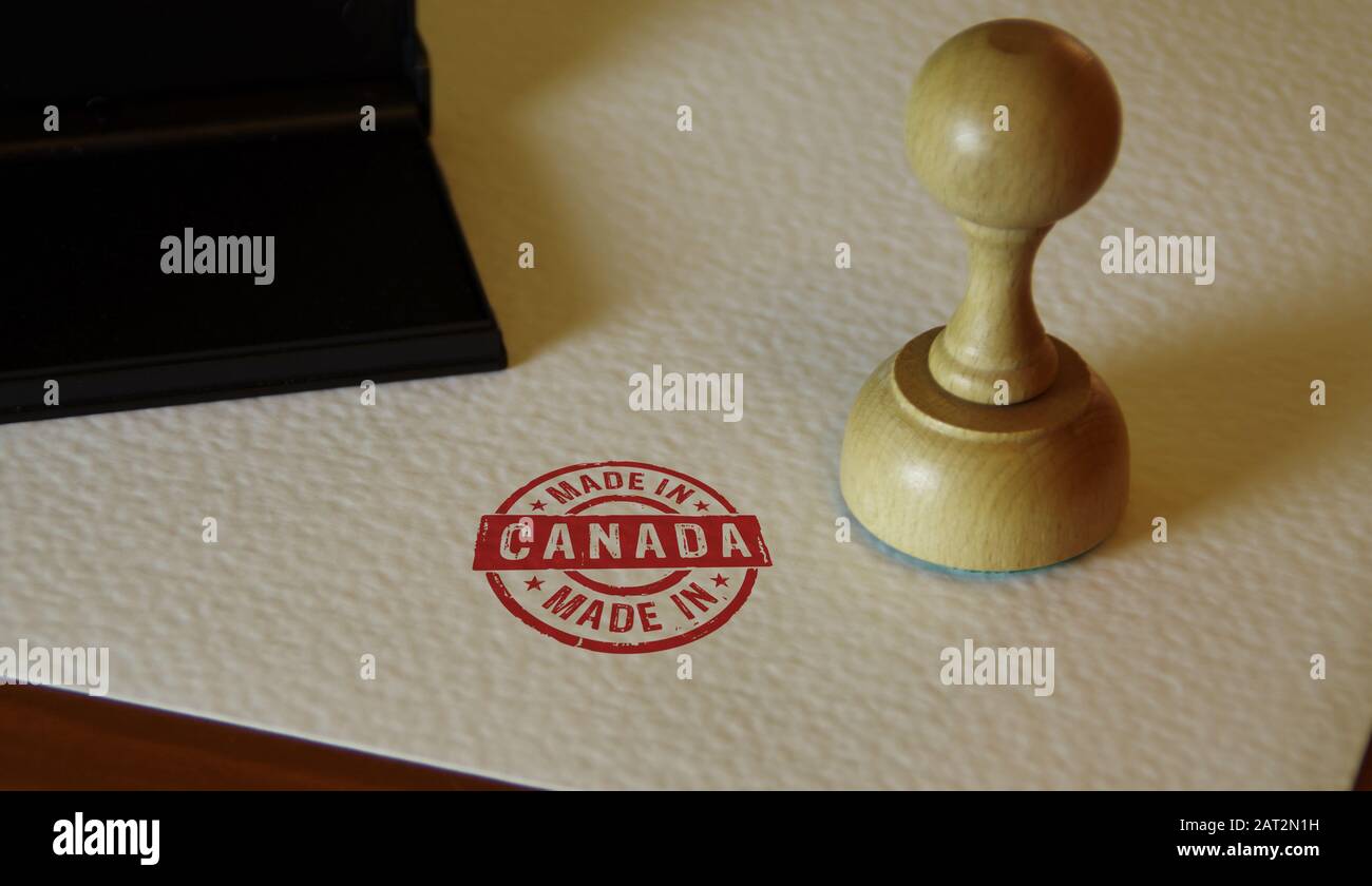 Made in Canada stamp and stamping hand. Factory, manufacturing and production country concept. Stock Photo