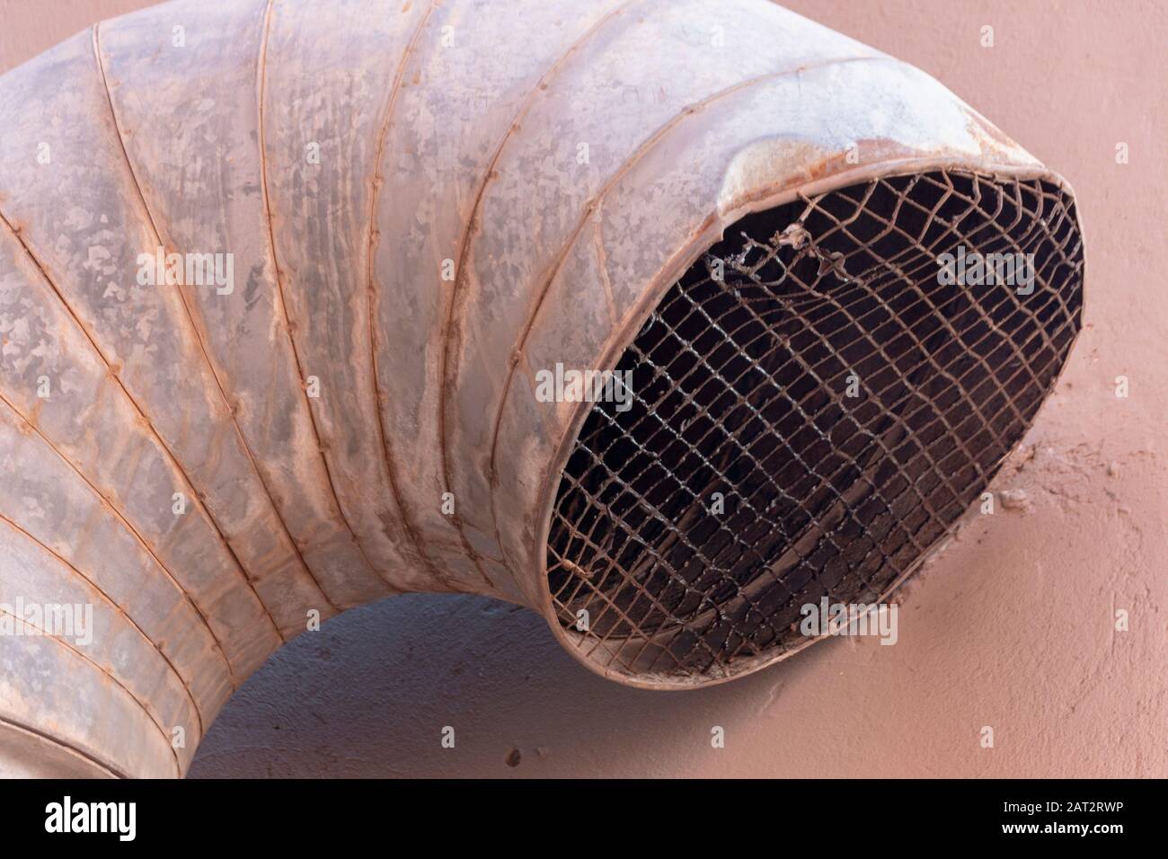 A close uo view of a large metal air vent attached to the side of a building Stock Photo