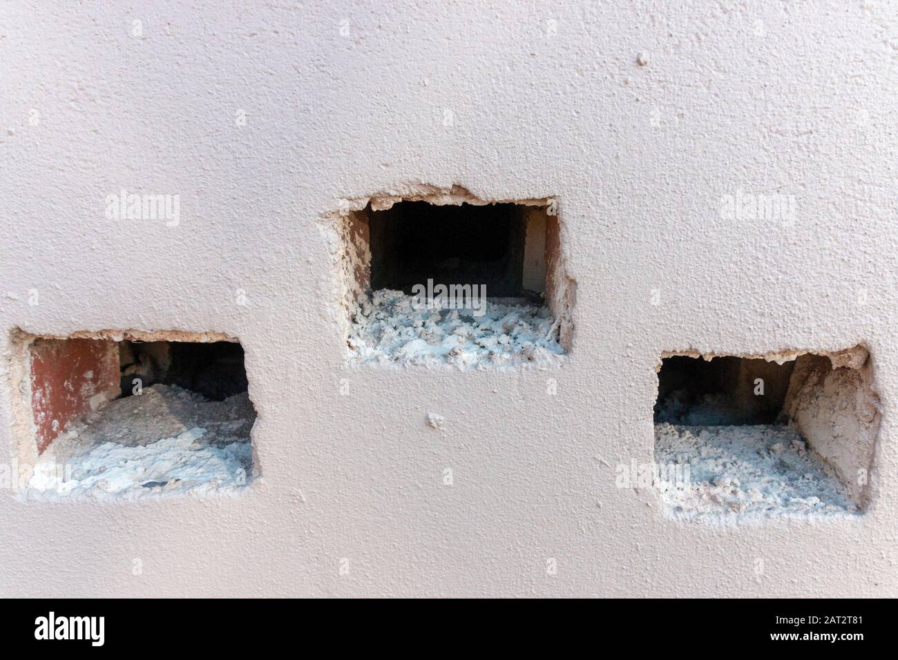 A close up view of the air vent wholes in the side of a building Stock Photo