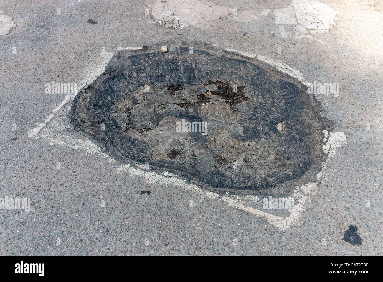 A close up view of a damaged area of tar that has been marked off for repair Stock Photo