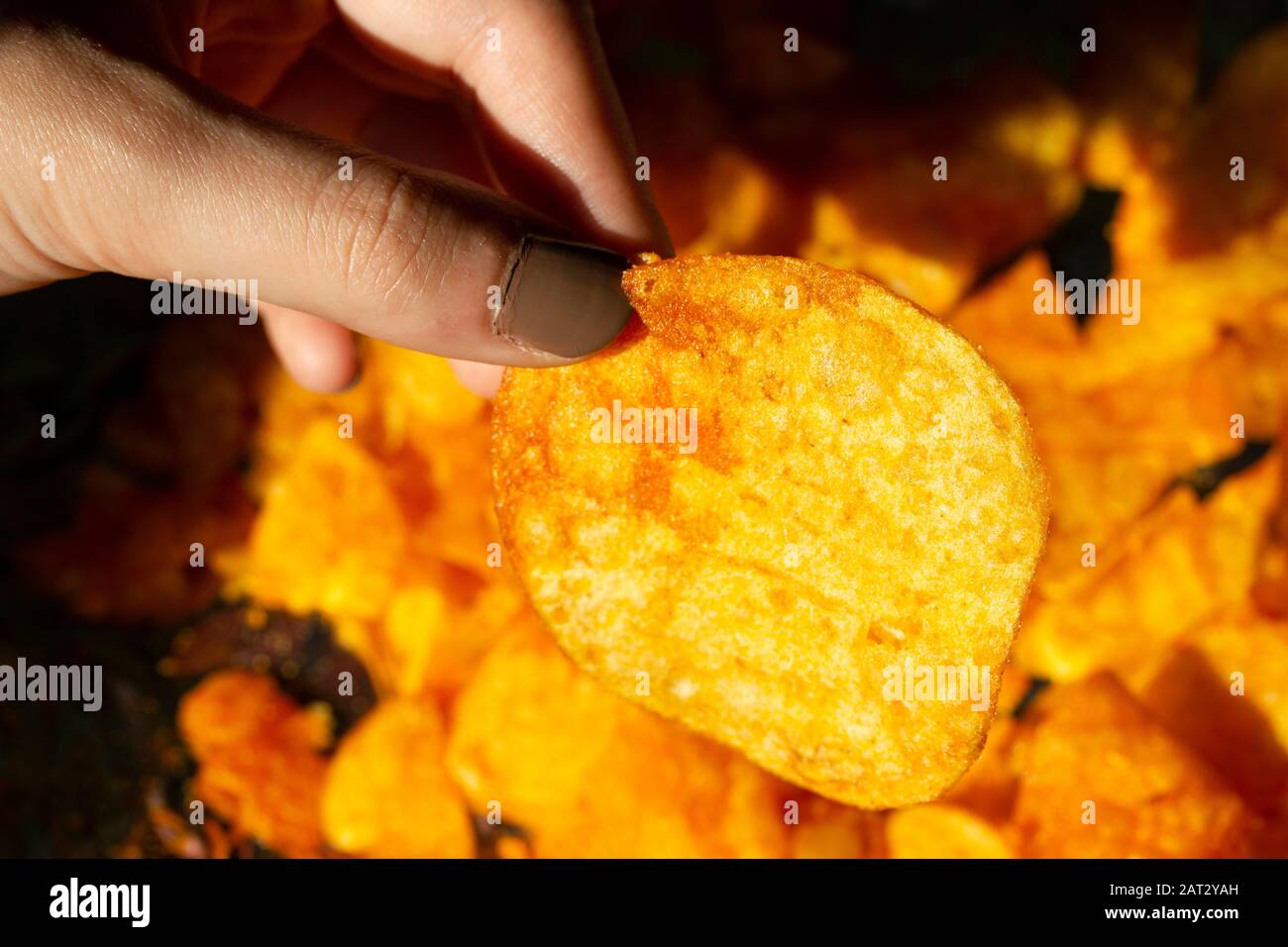 Woman eating chips snacks close up Stock Photo