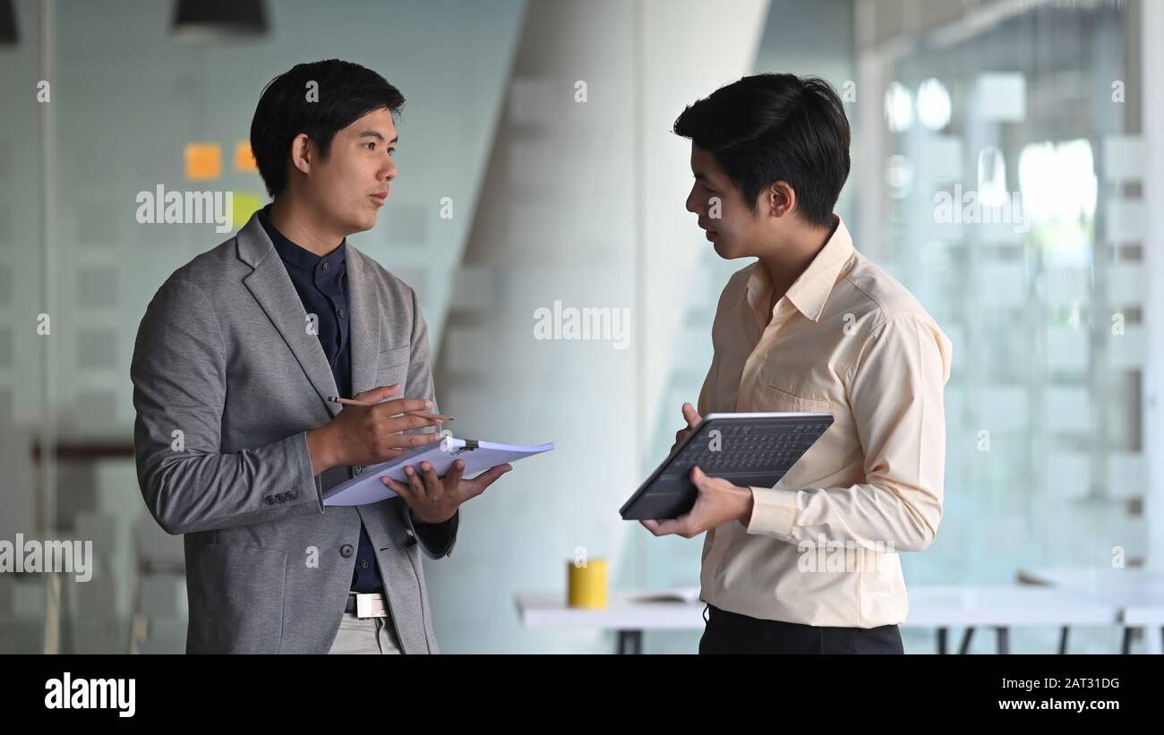 Photo of young business consulting man while talking/giving an advice to customer. Stock Photo