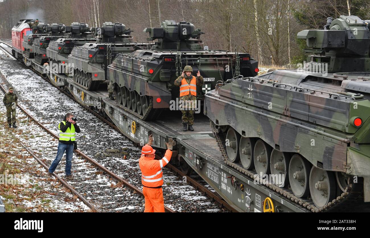 30 January 2020, Saxony, Marienberg: Soldiers of the Panzergrenadierbataillon 371 from Marienberg in Saxony load Marder infantry fighting vehicles onto railway goods trailers. With the transport, tanks 'Marder', recovery tanks 'Büffel' and wheeled vehicles go to Rukla in Lithuania. The Panzergrenadierbataillon 371 replaces there the Bataillon 391 from Bad Salzungen after its six-month engagement. The 'Marienberger Jäger' are participating in the contract for the second time. The main task is to show presence and practice together with multinational partners and the Lithuanian armed forces. Sin Stock Photo