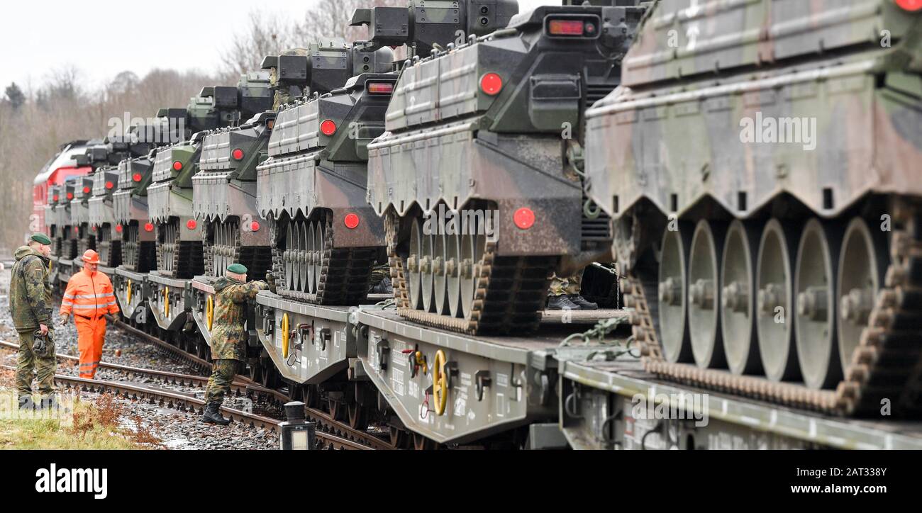 30 January 2020, Saxony, Marienberg: Soldiers of the Panzergrenadierbataillon 371 from Marienberg in Saxony load 'Marder' infantry fighting vehicles onto railway goods trailers. With the transport, tanks 'Marder', recovery tanks 'Büffel' and wheeled vehicles go to Rukla in Lithuania. The Panzergrenadierbataillon 371 replaces there the Bataillon 391 from Bad Salzungen after its six-month engagement. The 'Marienberger Jäger' are participating in the contract for the second time. The main task is to show presence and practice together with multinational partners and the Lithuanian armed forces. S Stock Photo